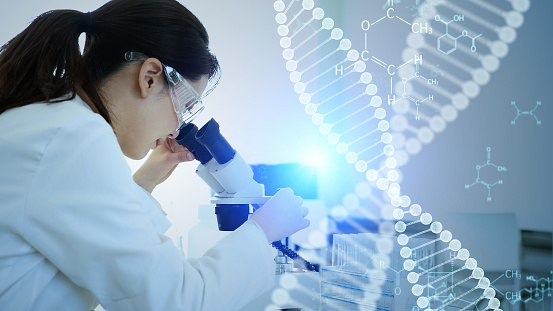 A woman looks into a microscope