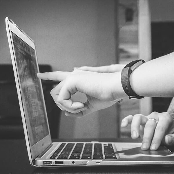 pointing at a laptop screen