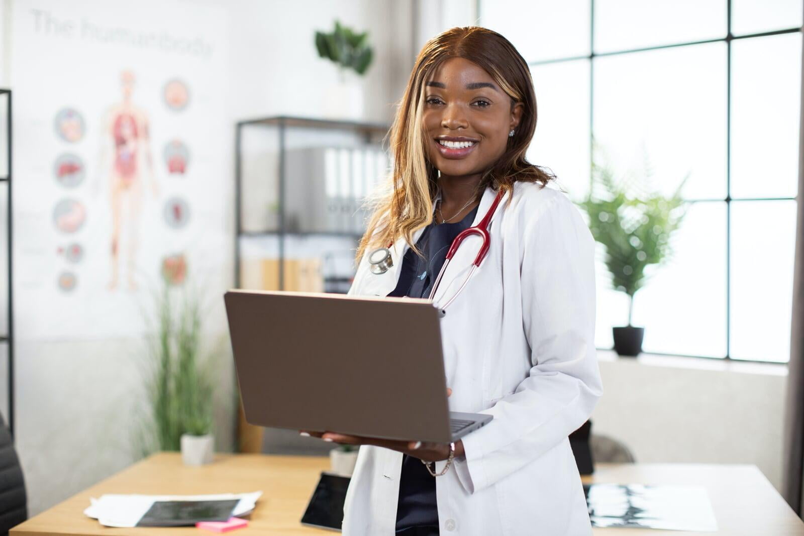 A medical professional works on a laptop in an office