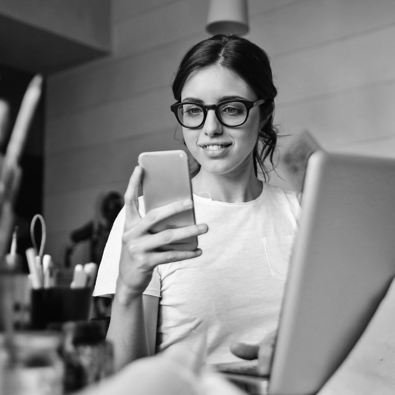 student at desk on smart phone