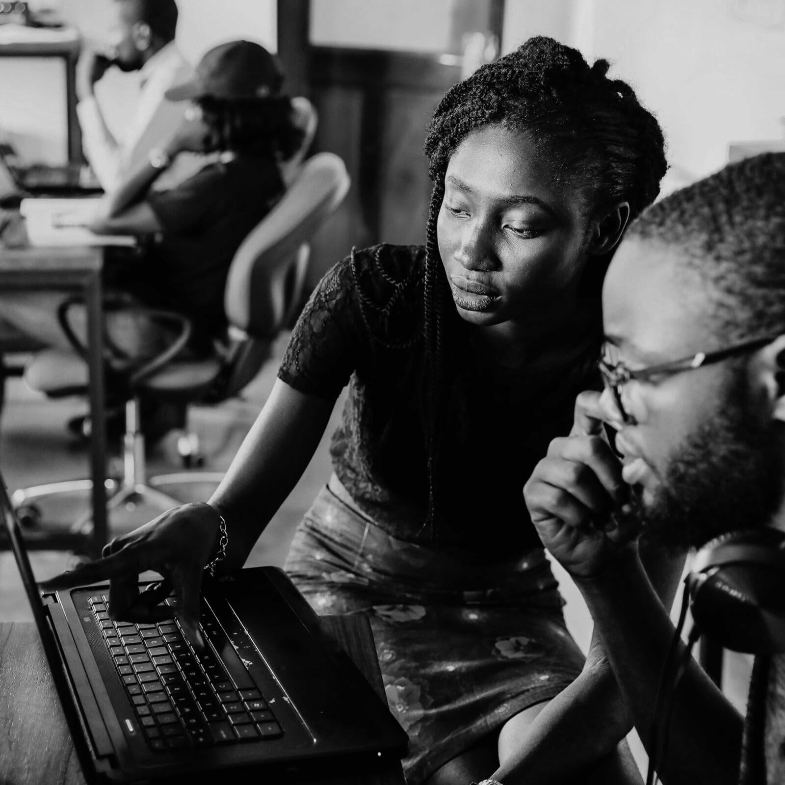 two students reading laptop screen